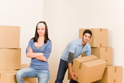 Helper carrying boxes during a flat move in Merton